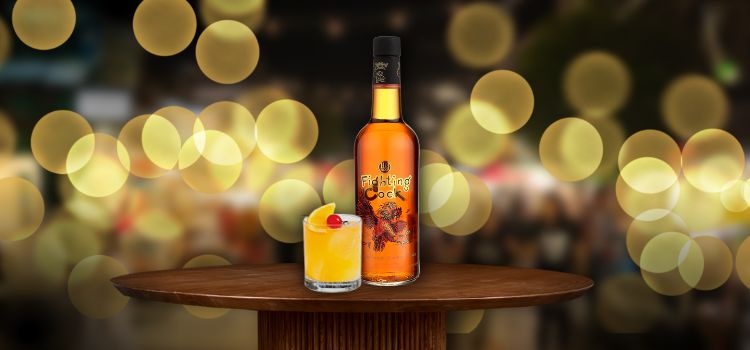 Fighting Cock on desk with old fashioned cocktail