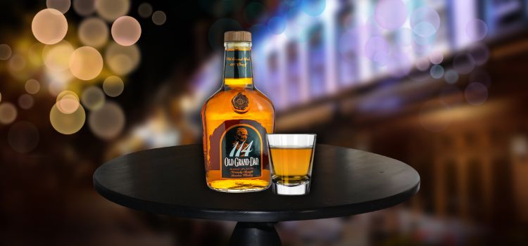 Old Grandad on desk with a shot of whiskey