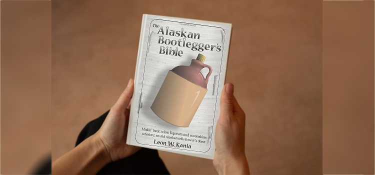 hand holding Book of The Alaskan Bootlegger's Bible