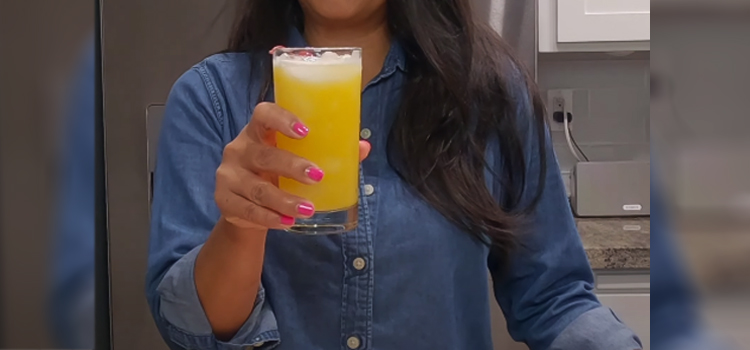 woman holding glass of pineapple juice