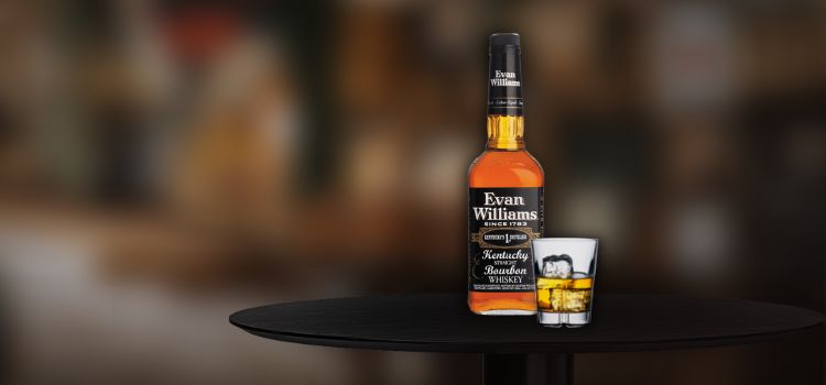 Evan Williams with glass on rocks on the desk