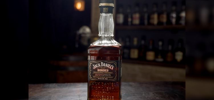 Jack Daniels Bonded Tennessee Whiskey Bottle on a Table with Shelves of Liquor on a background