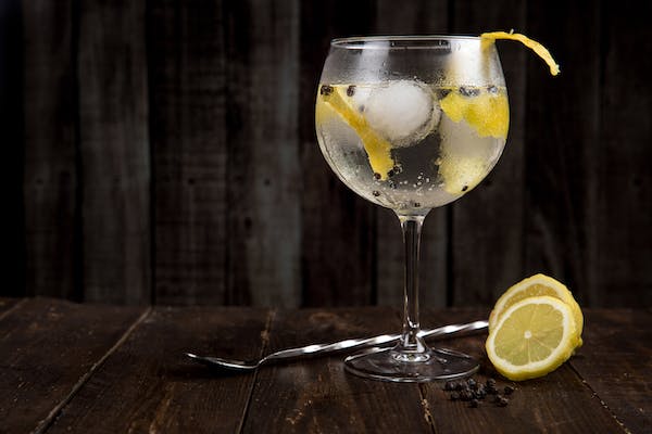 a glass of bourbon on the rocks paired with lemon